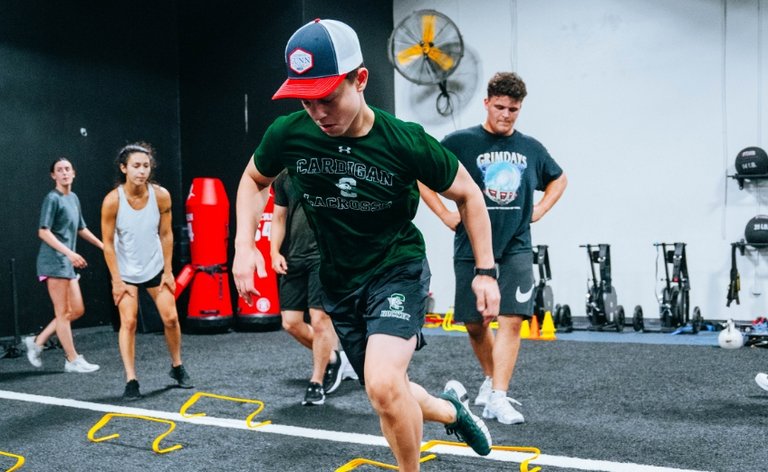 Teen boys and girls running drills at the gym