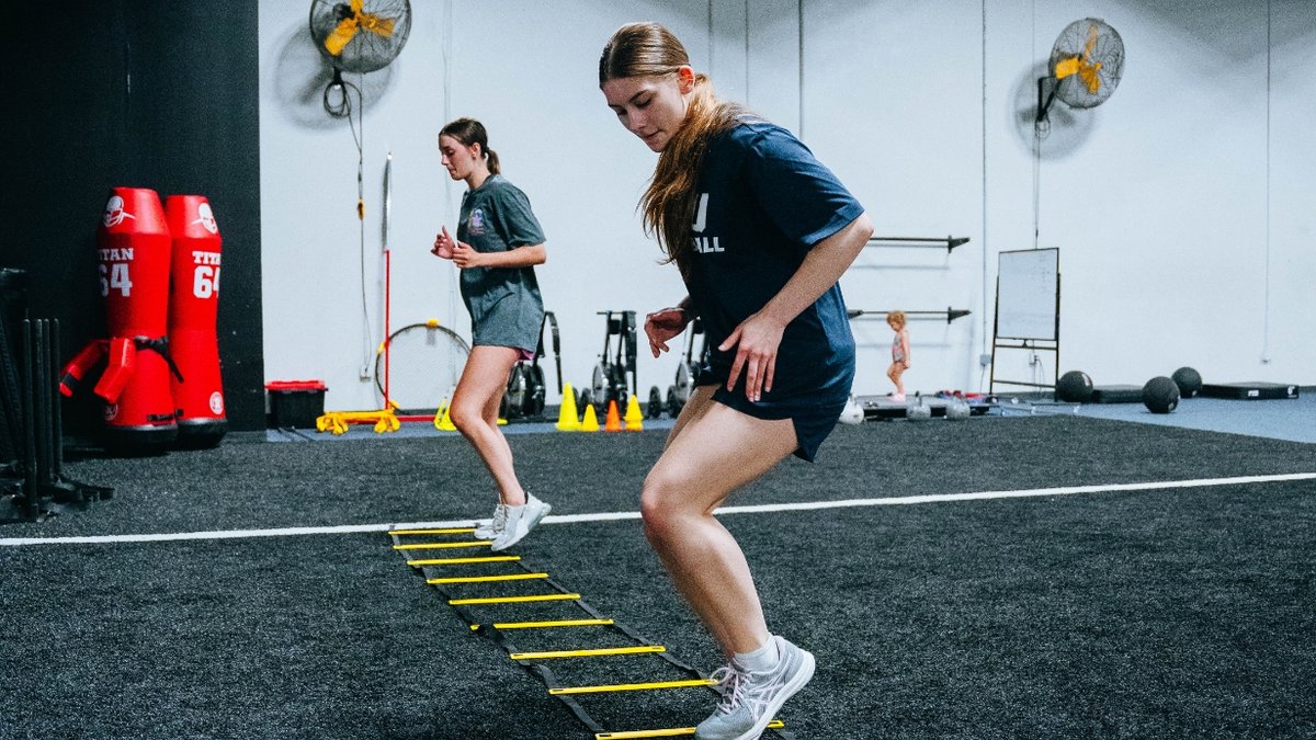 Two teenage girls exercising together at the gym