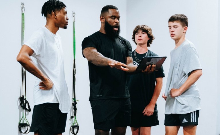 Trainer teaching a group of teen boys at the gym