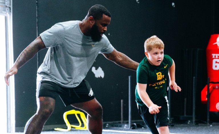 Trainer teaching a young boy proper running and exercise technique