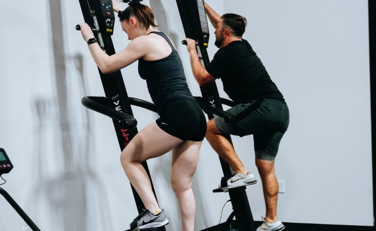 Male and female on stair climber equipment at the gym