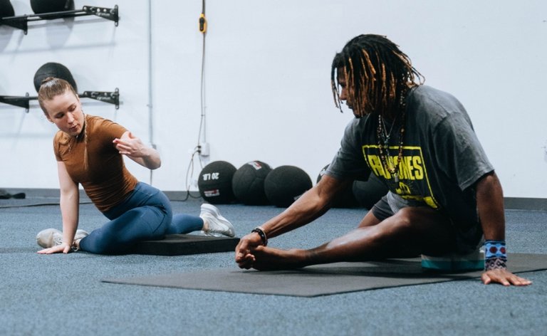 Man and woman doing stretches at the gym